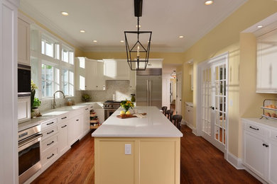 Mid-sized transitional l-shaped medium tone wood floor kitchen photo in Other with flat-panel cabinets, white cabinets, quartz countertops, marble backsplash, stainless steel appliances, an island and white countertops