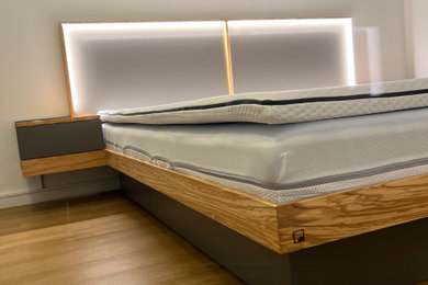 Großes Modernes Hauptschlafzimmer mit weißer Wandfarbe, dunklem Holzboden und braunem Boden in Sonstige