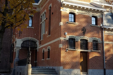 Cette image montre un grande façade d'immeuble traditionnel en pierre avec un toit à quatre pans.