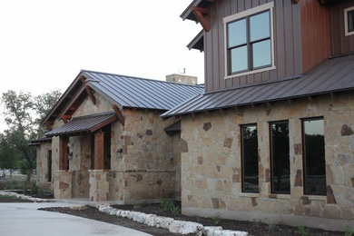 Inspiration for a country exterior in Austin with stone veneer and a gable roof.