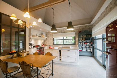 Aménagement d'une cuisine classique fermée avec un électroménager de couleur, îlot, un plafond en lambris de bois et papier peint.