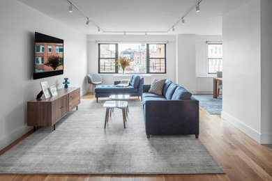 Inspiration for a large contemporary open concept light wood floor living room remodel in New York with white walls and a wall-mounted tv