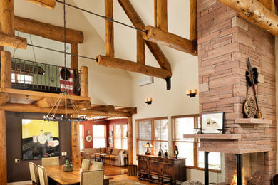 Design ideas for a transitional dining room in Denver with medium hardwood floors and a stone fireplace surround.