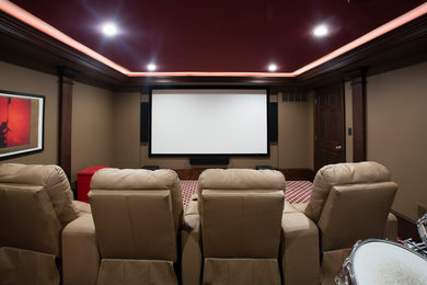 Home theater - large transitional enclosed carpeted and multicolored floor home theater idea in DC Metro with brown walls and a projector screen