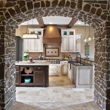 Old-World Stone Archway and Custom Cabinet Finishes Enhance This Houston Kitchen
