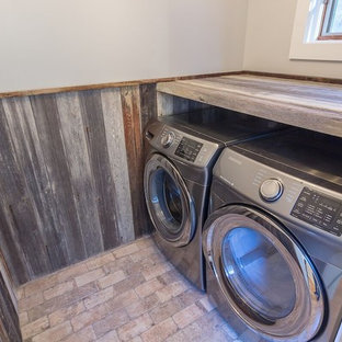Small rustic separated utility room in Burlington with distressed cabinets, grey walls, brick flooring and a side by side washer and dryer.