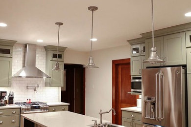 Mid-sized country galley light wood floor eat-in kitchen photo in Grand Rapids with a farmhouse sink, shaker cabinets, green cabinets, quartzite countertops, white backsplash, subway tile backsplash, stainless steel appliances and an island