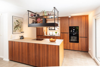 Ejemplo de cocina moderna de tamaño medio abierta con puertas de armario de madera en tonos medios y encimera de vidrio