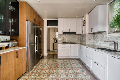 Ejemplo de cocinas en U minimalista grande cerrado con fregadero integrado, encimera de granito, salpicadero blanco, electrodomésticos negros y encimeras blancas