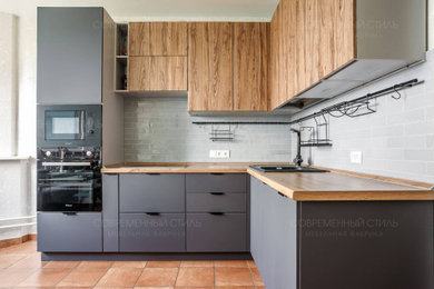 Идея дизайна: отдельная, угловая кухня среднего размера в стиле лофт с плоскими фасадами и серыми фасадами без острова