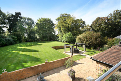 This is an example of a large contemporary backyard garden in Buckinghamshire with concrete pavers.