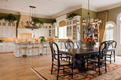 Example of a mid-sized mountain style l-shaped light wood floor and beige floor kitchen pantry design in DC Metro with raised-panel cabinets, beige backsplash, an island, white cabinets, granite countertops, a farmhouse sink, ceramic backsplash and paneled appliances