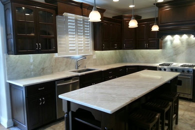 Eat-in kitchen - mid-sized transitional u-shaped ceramic tile eat-in kitchen idea in Chicago with dark wood cabinets, an island, a single-bowl sink, quartzite countertops, gray backsplash, stone slab backsplash, stainless steel appliances and raised-panel cabinets