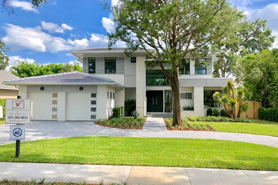 Inspiration for a large contemporary two-story concrete fiberboard house exterior remodel in Orlando with a hip roof and a tile roof