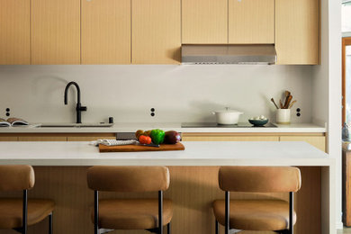 Mid-sized galley open concept kitchen photo in Sacramento with an undermount sink, flat-panel cabinets, light wood cabinets, quartz countertops, white backsplash, quartz backsplash, a peninsula and white countertops