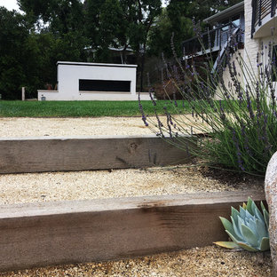 Großer Moderner Kiesgarten hinter dem Haus mit Kamin und direkter Sonneneinstrahlung in San Diego
