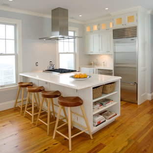 Пример оригинального дизайна интерьера: маленькая параллельная кухня в классическом стиле с раковиной в стиле кантри, белым фартуком, фартуком из каменной плиты, техникой из нержавеющей стали, паркетным полом среднего тона и полуостровом