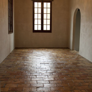 Design ideas for a large mediterranean open plan living room in Other with terracotta flooring and a stone fireplace surround.
