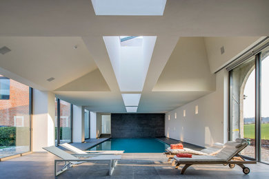 Photo of a mid-sized contemporary indoor rectangular pool in Cleveland with tile.