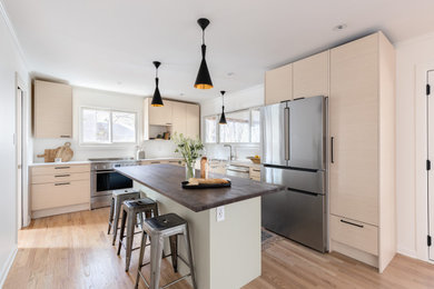 Inspiration for a modern l-shaped light wood floor enclosed kitchen remodel in Raleigh with an undermount sink, flat-panel cabinets, light wood cabinets, quartz countertops, white backsplash, stainless steel appliances, an island and white countertops
