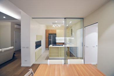 Esempio di una cucina ad U minimal chiusa e di medie dimensioni con lavello da incasso, ante lisce, ante beige, top in quarzite, elettrodomestici neri, pavimento in gres porcellanato, pavimento grigio e top bianco
