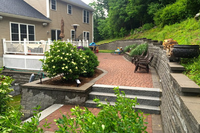 Large elegant backyard brick patio photo in Boston with no cover