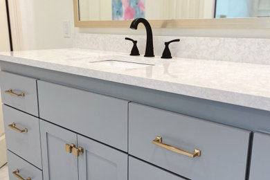 Example of a large transitional master white tile and porcelain tile porcelain tile, white floor and double-sink bathroom design in New Orleans with shaker cabinets, blue cabinets, a two-piece toilet, white walls, an undermount sink, quartz countertops, white countertops and a built-in vanity
