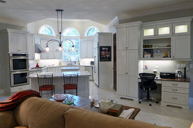 Example of a mid-sized transitional u-shaped ceramic tile and white floor open concept kitchen design in Houston with an undermount sink, recessed-panel cabinets, white cabinets, granite countertops, stainless steel appliances and two islands