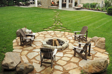 Inspiration for a large timeless backyard stone patio remodel in Columbus with a fire pit