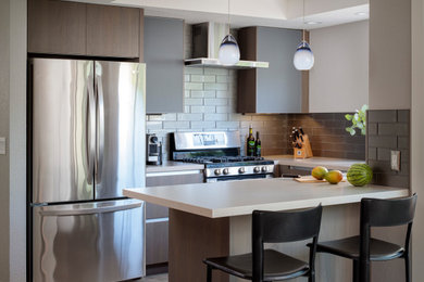 Small contemporary u-shaped separate kitchen in San Francisco with flat-panel cabinets, brown cabinets, quartz benchtops, grey splashback, ceramic splashback, stainless steel appliances, grey floor and white benchtop.