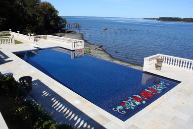 Photo of a large traditional backyard rectangular infinity pool in New York with natural stone pavers.