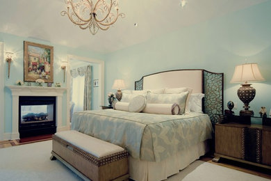 Inspiration for a large timeless master light wood floor bedroom remodel in New York with a two-sided fireplace