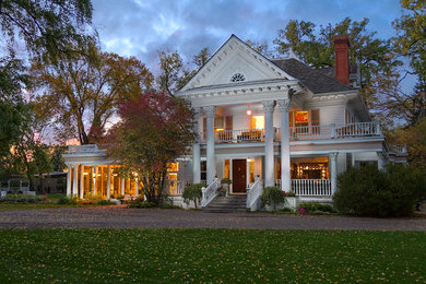 Example of a classic white two-story wood exterior home design in Calgary with a shingle roof