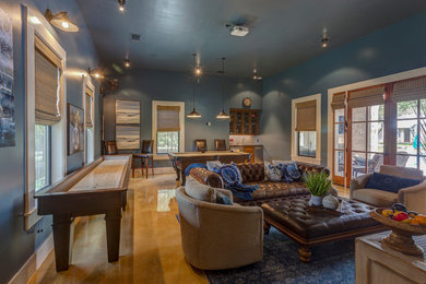 Inspiration for a large country open concept family room in Austin with a game room, blue walls, concrete floors, no fireplace, a wall-mounted tv and beige floor.