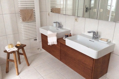 Foto de cuarto de baño doble y flotante actual con armarios con paneles lisos y puertas de armario de madera en tonos medios