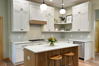 Mid-sized transitional l-shaped medium tone wood floor and brown floor open concept kitchen photo in Other with an undermount sink, flat-panel cabinets, white cabinets, quartz countertops, gray backsplash, ceramic backsplash, stainless steel appliances, an island and white countertops