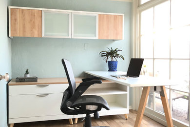 Ejemplo de despacho actual pequeño con paredes azules, suelo vinílico y escritorio independiente