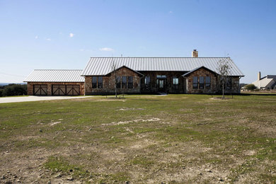Mid-sized farmhouse beige one-story stone exterior home photo in Austin