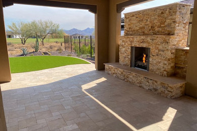Design ideas for a large traditional back patio in Phoenix with a fireplace and natural stone paving.