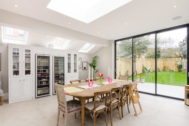Inspiration for a medium sized traditional kitchen/dining room in London with white walls, ceramic flooring, no fireplace and white floors.