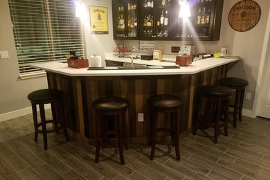 Arts and crafts u-shaped laminate floor and beige floor seated home bar photo in Denver with an undermount sink, glass-front cabinets, dark wood cabinets and beige backsplash