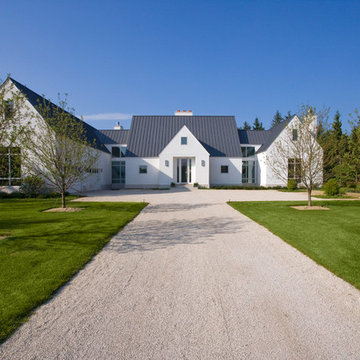 Front Elevation of Contemporary European Farmhouse in White Stucco Metal Roof