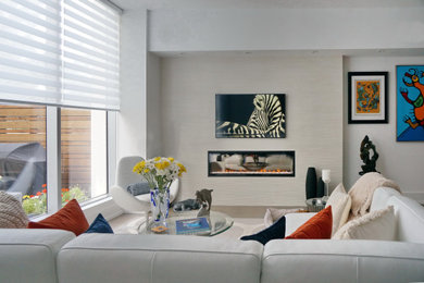 Imagen de salón contemporáneo con paredes blancas, suelo de madera en tonos medios, chimenea lineal, marco de chimenea de baldosas y/o azulejos y televisor colgado en la pared