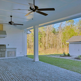 ジャクソンビルの大きいカントリー風おしゃれな裏庭のテラス (アウトドアキッチン、張り出し屋根、レンガ敷き) の写真