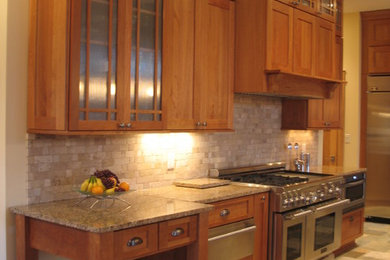 Inspiration for a mid-sized craftsman l-shaped slate floor eat-in kitchen remodel in Indianapolis with an undermount sink, recessed-panel cabinets, light wood cabinets, granite countertops, black backsplash, stone tile backsplash, stainless steel appliances and an island