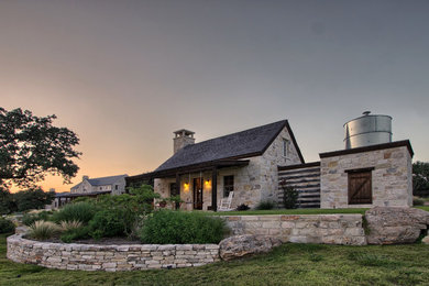 Example of a mid-sized mountain style beige one-story stone exterior home design in Austin with a shingle roof