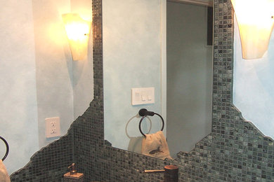 Inspiration for a contemporary powder room in Chicago with flat-panel cabinets, medium wood cabinets, a one-piece toilet, green tile, gray tile, mosaic tile, blue walls and a vessel sink.