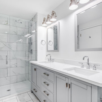 Primary bathroom with beautiful grey cabinets and white counter top.