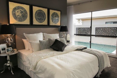 This is an example of a contemporary master bedroom in Townsville with grey walls and carpet.