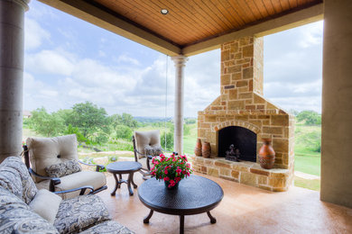 Patio - large mediterranean backyard stamped concrete patio idea in Austin with a fire pit and a roof extension
